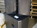 two speakers sitting on top of each other in a warehouse