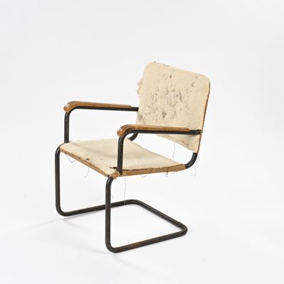 Cette chaise est en bois et en métal, avec une assise en cuir.