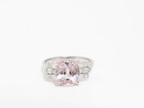 une bague sertie d'un saphir rose et de diamants sur fond blanc