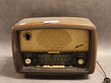 une radio à l'ancienne posée sur une table près d'un mur