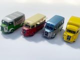 quatre camions miniatures posés côte à côte sur une surface blanche