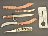 five different types of knives on a table next to a ruler