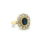 a close up of a gold ring with a blue stone surrounded by diamonds