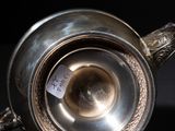 a silver tea pot on a black table