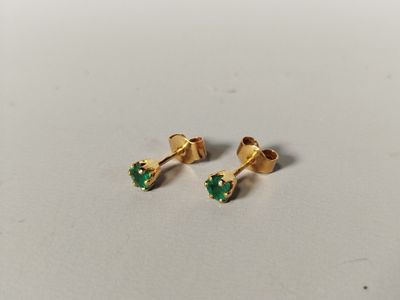 a pair of gold earrings with green stones on them