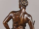 bronze statue of a boy with a dog on a marble base