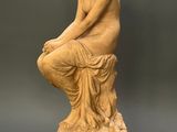 an image of a statue of a woman sitting on a pedestal