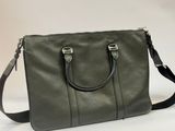 a green handbag sitting on top of a white table
