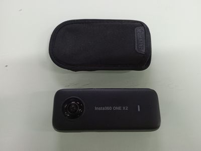 two black cell phones sitting next to each other on a table