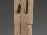 une vieille statue en bois d'un homme avec un chapeau sur la tête