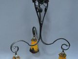 an image of a chandelier with two yellow glass lamps hanging from it