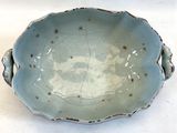 un bol bleu posé sur une table, sur fond blanc