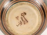 a brown and black vase with writing on it