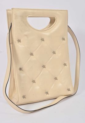 a white purse with silver stars on it and a strap