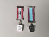 deux médailles ornées d'une croix et une médaille sur fond blanc