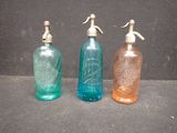 three different colored glass bottles sitting next to each other