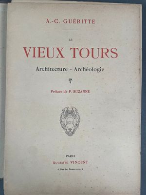 un vieux livre posé sur une table à côté d'un mur bleu
