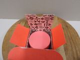 a box with a pink object inside of it on a table