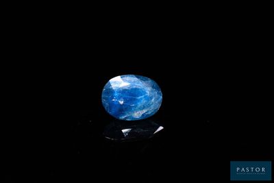 un gros plan d'une pierre bleue et blanche sur une surface noire