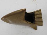 a gold fish shaped object on a white surface