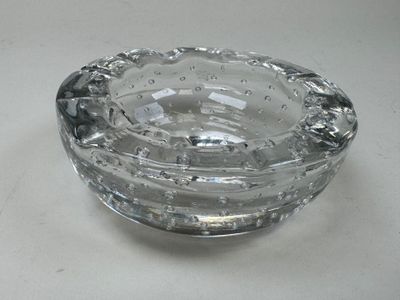 a glass ashtray on a table with water in it