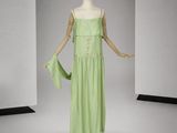 un mannequin vêtu d'une robe verte dans une pièce