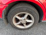 a close up of a red car with a flat tire