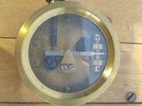 a close up of a clock on a wooden table