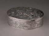 an antique silver box with a scene on it sitting on a table