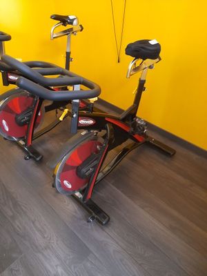 deux vélos d'appartement dans une salle de sport aux murs jaunes