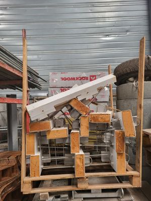 Plusieurs morceaux de bois sont empilés sur une palette dans un entrepôt