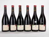 six bouteilles de vin alignées sur une surface blanche
