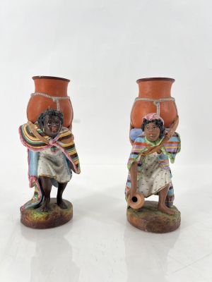 deux figurines représentant un homme et une femme portant un pot