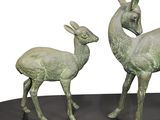 two statues of a deer and a deer on a black base