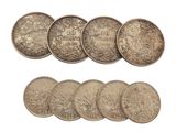 a bunch of coins sitting next to each other on top of a white surface
