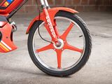 a close up of a small red bike parked in a garage