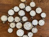 a lot of clocks that are on a wooden table