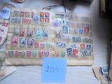 de nombreux timbres posés sur une table, à côté d'un panneau bleu