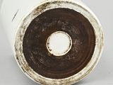 a close up of a white vase with a brown rim