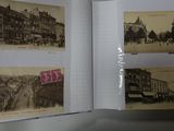 a person holding a book open to a picture of a city