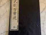 un livre noir portant des inscriptions en chinois, posé sur une table en marbre