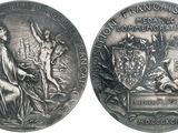 une vieille médaille en argent sur laquelle figurent les portraits d'une femme et d'un homme