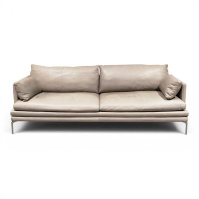 an image of a beige leather couch with pillows on a white background