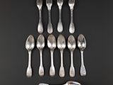 six silver spoons and two silver spoons on a black surface