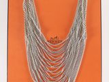 un gros plan d'un collier à chaîne en argent sur fond orange
