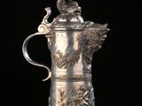 une cafetière ancienne en argent surmontée d'un oiseau