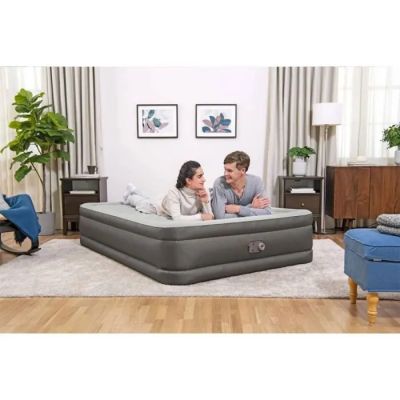 an image of a man and woman sitting on an air mattress in a living room