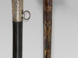 an image of a sword and a cane on a white surface