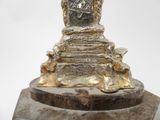 a statue of a woman sitting on a throne on a marble base