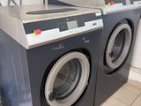 une photo d'un lave-linge et d'un sèche-linge dans une buanderie
